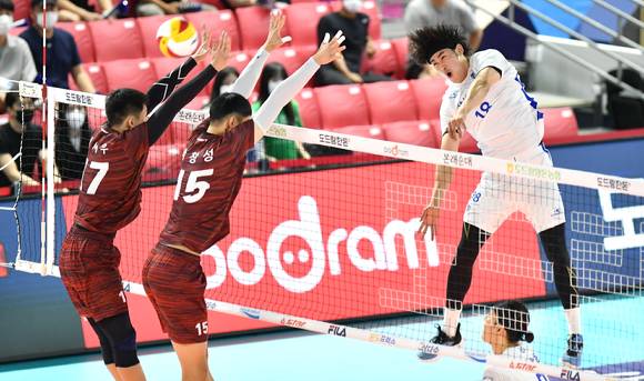 삼성화재 홍민기(오른쪽)가 22일 열린 2022 순천·도드람컵 대회 남자부 B조 조별리그 상무(국군체육부대)와 첫 경기 도중 상대 블로커 사이로 스파이크를 시도하고 있다. [사진=한국배구연맹(KOVO)]