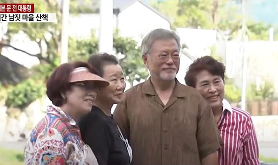 문재인 전 대통령이 22일 오후 경남 양산 평산마을에서 방문객들과 기념사진을 촬영하고 있다. 사진 YTN 유튜브 캡처