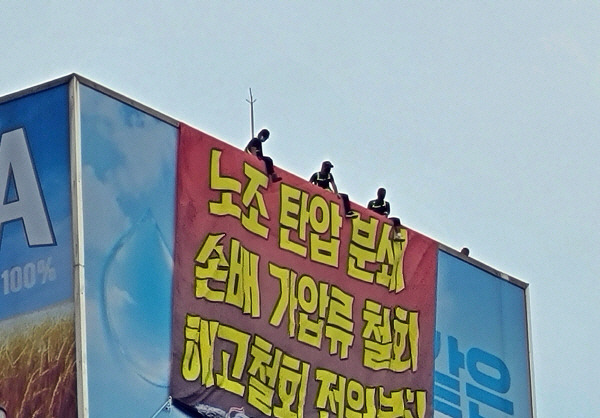 화물연대 조합원들이 지난 18일 오후 서울 강남구 청담동 하이트진로 본사 옥상에서 고공 농성을 벌이고 있다. [이상현 기자]