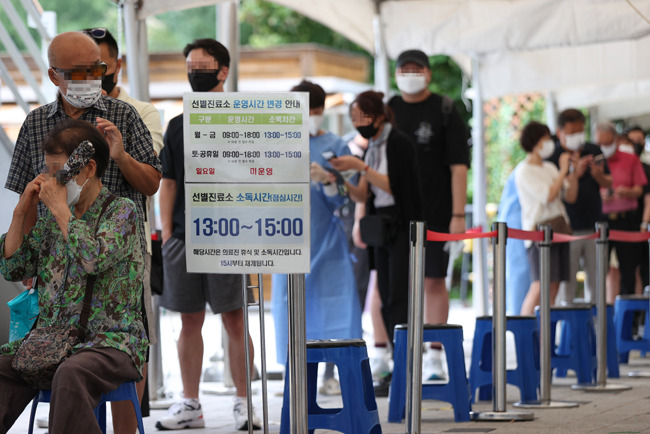 23일 오전 서울 마포구보건소에 마련된 선별진료소에서 시민들이 검사를 기다리며 줄을 서고 있다. 연합뉴스