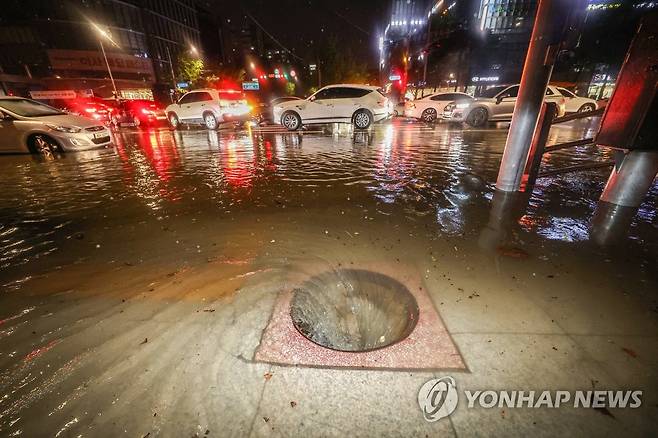 지난 9일 새벽 폭우로 다수의 차량이 침수된 서울 강남구 대치사거리의 배수구가 뚜껑이 없어진 채 소용돌이치고 있다. [연합뉴스 자료사진]