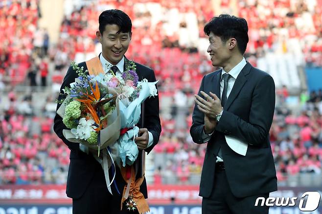 잉글랜드 프로축구 프리미어리그(EPL)에서 아시아 선수 최초로 득점왕을 차지한 손흥민이 2일 서울월드컵경기장에서 2002 한일월드컵 20주년 기념 평가전 대한민국-브라질의 경기에 앞서 윤석열 대통령으로부터 체육훈장 최고등급인 청룡장을 수여받은 뒤 박지성에게 축하받고 있다. 2022.6.2/뉴스1 ⓒ News1 오대일 기자