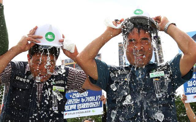 민주노총 건설노조 조합원들이 24일 오전 서울 용산구 대통령 집무실 인근에서 열린 건설현장 폭염 실태 폭로 및 법제화 촉구 기자회견에서 '시원한 폭염법 촉구' 아이스 안전모 챌린지를 하고 있다. 뉴시스