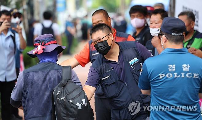 하이트진로 로비 점거 해제한 화물연대 (서울=연합뉴스) 김도훈 기자 = 24일 오전 하이트진로 본사 앞에서 공공운수노조 화물연대 인천지역본부 김근영 본부장이 로비 점거를 해제하고 서울 강남구 본사 건물을 나선 조합원을 격려하고 있다.
    하이트진로 측에 집단해고 및 손해배상철회를 촉구하며 본사 로비와 옥상 점거 농성을 벌여온 화물연대는 고공농성은 이어가되 하이트진로와의 대화 물꼬를 트기 위해 본사 로비 농성을 해제한다고 밝혔다. 2022.8.24 superdoo82@yna.co.kr