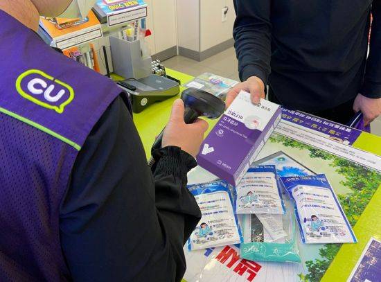 편의점 CU에서 고객이 자가검사키트를 구매하고 있다.