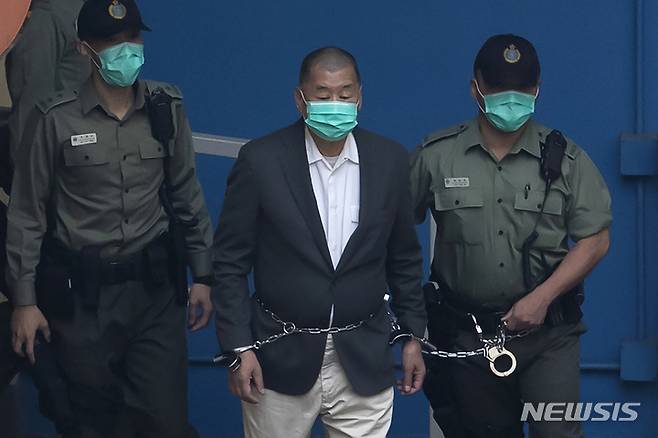[홍콩=AP/뉴시스]홍콩 언론계의 거물 이자 민주화 운동가 지미 라이가 지난 2020년 12월12일 교도관들의 호위 속에 법정으로 출두하고 있다. 라이의 변호인단은 유엔에 그의 투옥과 여러 가지 범죄 혐의를 법적 괴롭힘으로 조사해줄 것을 요청하고 있다. 2022.4.11