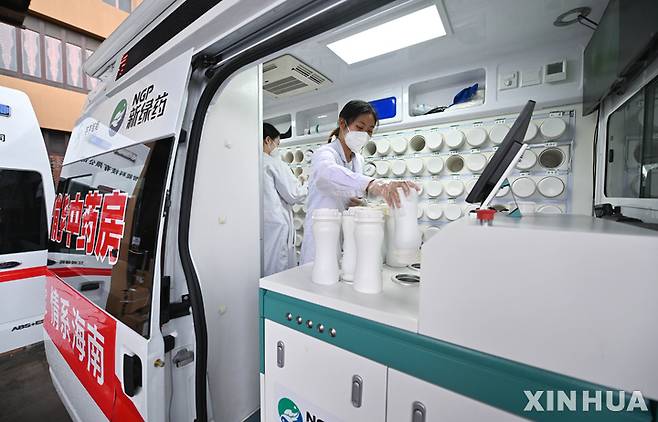 [싼야=신화/뉴시스] 코로나19가 급속도로 퍼진 중국 하이난성 남부 관광지 싼야 시내에 21일 출동한 이동약국에서 약제사들이 한약을 만들고 있다. 2022.08.24