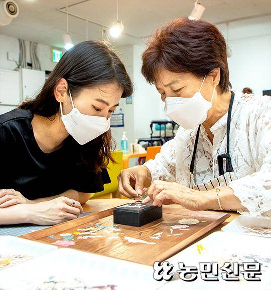 이영옥 명장(오른쪽)에게 자개 붙이는 방법을 배우고 있다.