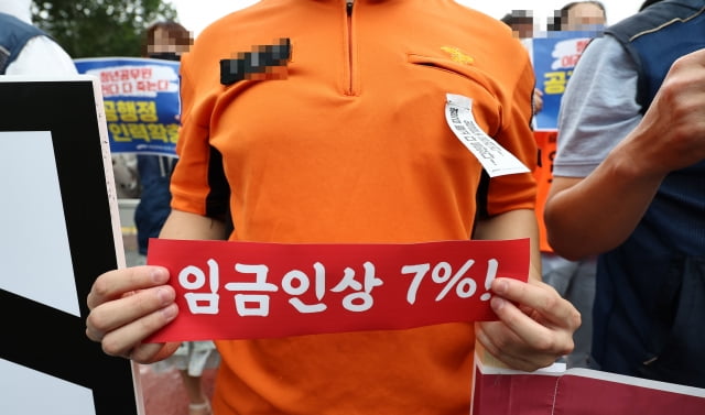 8일 오전 서울 용산구 전쟁기념관 앞에서 열린 공무원 2023년 임금 7% 인상 및 인력감축 중단 촉구 기자회견에서 참석자들이 손팻말을 들고 있다. / 사진=연합뉴스