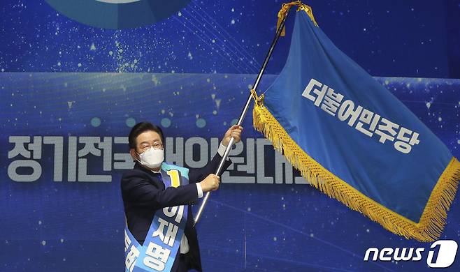 이재명 더불어민주당 신임 당대표가 28일 서울 송파구 올림픽공원 체조경기장에서 열린 민주당 제5차 정기전국대의원대회에서 당대표로 선출된 뒤 이양받은 당기를 흔들고 있다. (공동취재) 2022.8.28/뉴스1 ⓒ News1 허경 기자