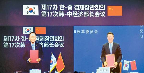 지난 27일 추경호 경제부총리 겸 기획재정부 장관(왼쪽)과 허리펑 중국 국가발전개혁위원회 주임이 서울 중구 롯데호텔에서 영상으로 열린 제17차 한중 경제장관회의에 참석해 합의 의사록을 들고 기념촬영을 하고 있다. [사진 출처 = 연합뉴스]