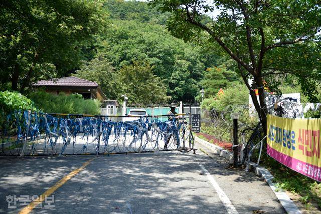 차량이 25일 경북 성주군 초전면 소성리 사드기지에 진입하는 사이 군 장병이 출입문을 닫고 있다. 성주=류수현 기자