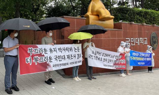 지난 8월 8일 국민대 정문 앞에서 국민대 동문 비상대책위원회가 윤석열 대통령 부인 김건희 여사가 2007년 쓴 박사학위 논문 조사결과에 항의하는 현수막을 들고 시위를 하고 있다. / 연합뉴스
