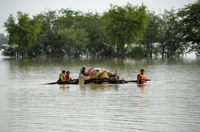 ▲28일(현지시각) 파키스탄 남서부 발루치스탄주 자파라바드에서 주민들이 가재도구를 뗏목에 싣고 홍수 지역을 빠져나가고 있다. ⓒAP=연합뉴스 