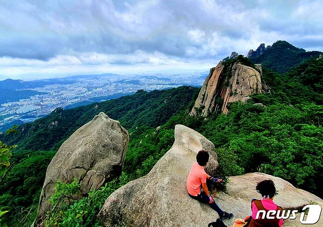 포대능선에서. 포대능선 바위에 올라 웅장한 도봉산과 북서울 시내를 바라보는 사람들