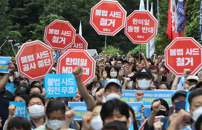 원불교 진밭평화기도 2000일과 사드 추가반입 5년 즈음한 13차 범국민 평화행동이 3일 오후 성주군 진밭교에서 열려 참석자들이 불법사드 철거 및 기지공사 중단을 촉구하는 내용이 적힌 손팻말을 들어 보이고 있다. 신소영 기자 viator@hani.co.kr