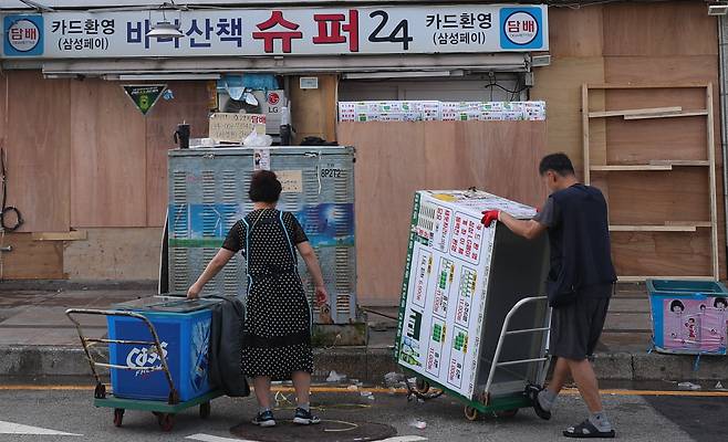 제11호 태풍 힌남노가 북상 중인 가운데 4일 오후 부산 수영구 민락수변공원 앞 상인들이 폭풍에 대비해 합판을 이용한 차수벽을 설치하고 상가 안의 냉장고와 식품들을 창고로 옮기고 있다.수변공원 인근에서 장사를 하고 있는 한 상인은 '20년이 다 되어 가지만 태풍 매미를 생각하면 아직도 끔찍하다'고 말했다/ 2022.09.04 김동환 기자