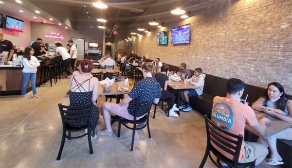 미국 버지니아주 우드브리지의 BBQ 포토맥타운센터점에서 현지인들이 한국식 양념 치킨을 먹고 있다. 최근 미국에서는 K치킨이 큰 인기를 끌면서 BBQ 신규 출점 문의로 대기 중인 인원만 500여 명에 달하는 것으로 알려졌다. [사진 제공 = 제너시스BBQ]