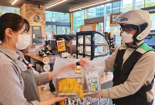 편의점 이마트24 매장에서 배달원이 상품을 건네받고 있다. 사진은 기사 내용과 관계 없음. (사진= 이마트 24).