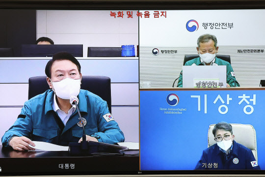 윤석열 대통령이 5일 밤 서울 용산 대통령실 청사 국가위기관리센터에서 제11호 태풍 '힌남노'와 관련 제주 현지 CCTV 영상을 통해 태풍 상륙 상황을 지켜보며 유희동 기상청장으로부터 화상 보고를 받고 있다. 대통령실 제공