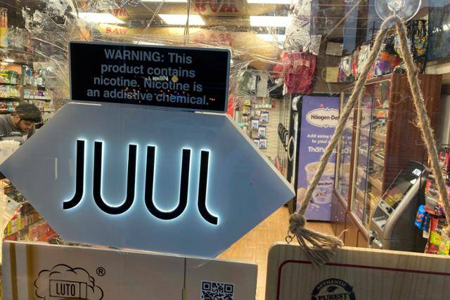 지난 6월 25일 미국 뉴욕에 있는 한 편의점에 전자담배 '쥴(JUUL)'을 판매한다는 표지판을 문 앞에 걸어둔 모습. 뉴욕=AP 연합뉴스