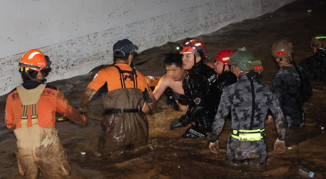 6일 폭우로 잠긴 경북 포항시 인덕동 W아파트 지하주차장에서 소방·군 관계자들이 주민 전모씨를 구조하고 있다. 연합뉴스