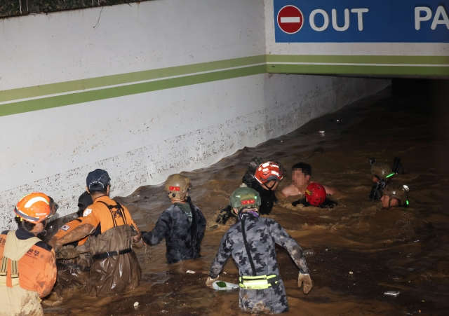 6일 저녁 태풍 '힌남노'의 폭우로 잠긴 경북 포항시 남구의 한 아파트 지하 주차장에서 소방·군 관계자들이 실종됐던 남성 주민을 구조하고 있다. 연합뉴스