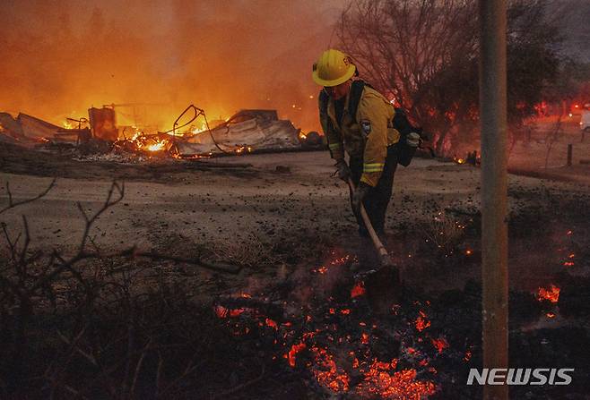[이단 스워피=AP/뉴시스] 5일(현지시간) 캘리포니아 헤멧에서 버몬트 소방국 소방대원 이안 프렘드(Ian Fremd)가 페어뷰 화재를 진압하며 잔불을 끄고 있다. 2022.09.07.