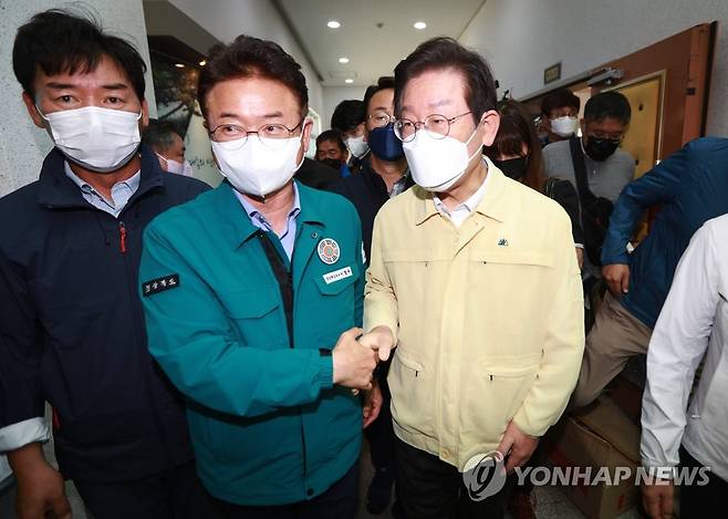 악수하는 이재명 대표와 이철우 경북지사 (포항=연합뉴스) 김현태 기자 = 더불어민주당 이재명 대표가 7일 오전 태풍 피해지역인 경북 포항시 남구 대송면 일대를 찾아 피해 상황을 살펴보다가 현장을 찾은 이철우 경북지사와 인사하고 있다. 2022.9.7 mtkht@yna.co.kr
