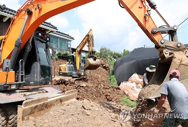 충주시 호우피해 응급복구 중 (충주=연합뉴스) 충북 충주시는 20일 집중호우로 옹벽이 무너진 엄정면의 한 주택 앞에서 복구작업을 시행했다. 2022.8.20 [충주시 제공. 재판매 및 DB 금지] ks@yna.co.kr