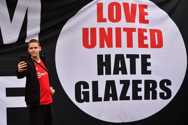 지난달 한 팬이 '유나이티드를 사랑하지만 글레이저 가문은 싫어한다'는 문구 앞에서 셀카를 찍는 모습. / AFP 연합뉴스