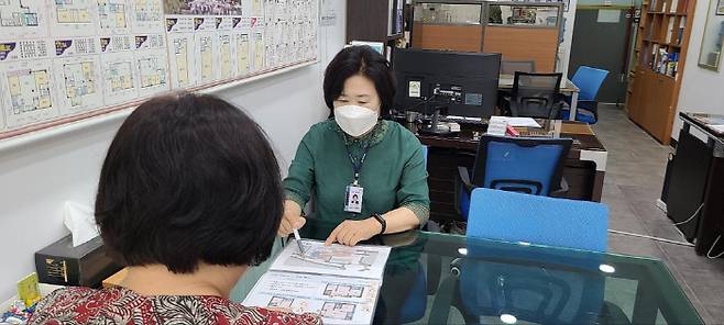 부동산공인중개사가 신분증을 목에 걸고 업무를 보는 모습. [사진 제공 = 서초구]