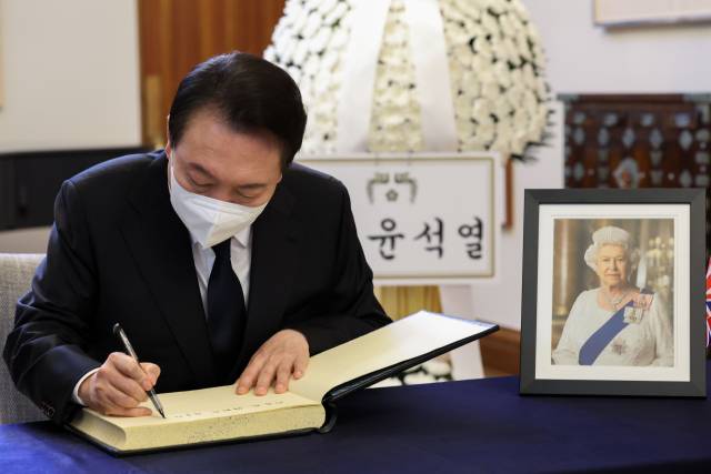 윤석열 대통령이 9일 주한영국대사관에 설치된 엘리자베스 2세 여왕 분향소를 찾아 조문한 뒤 방명록을 작성하고 있다. / 연합뉴스