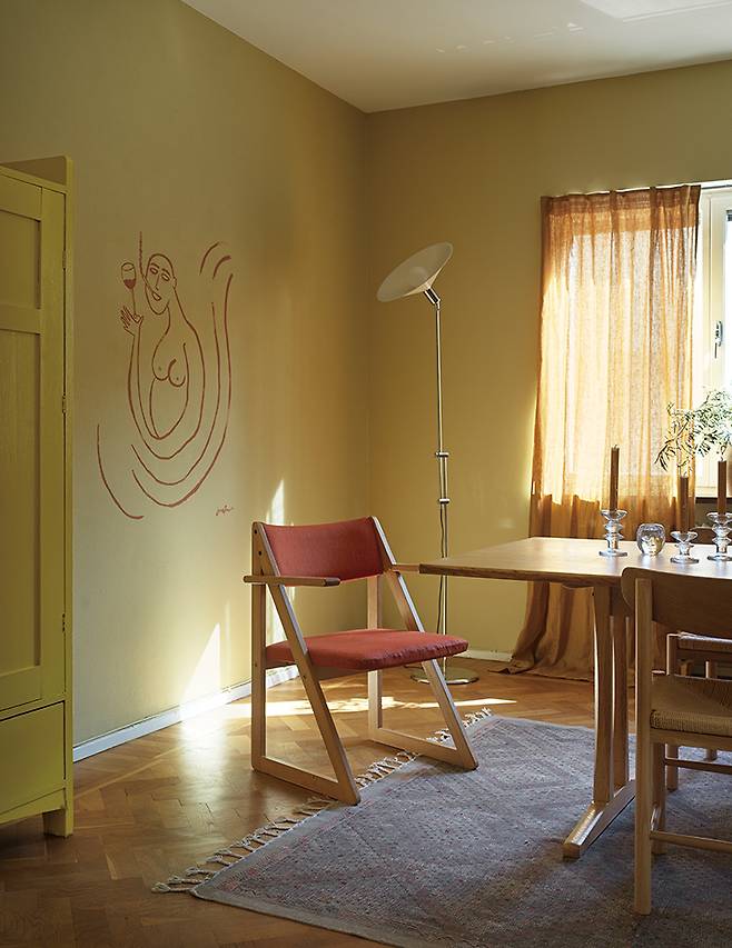 다이닝 룸에 놓인 린다우 & 린데크란츠(Lindau & Lindecrantz)의 ‘제로’ 플로어 램프와 뵈르게 모겐센(Børge Mogensen)이 디자인한 식탁은 경매에서, 빨간 시트의 의자는 플리마켓에서 구입했다.
