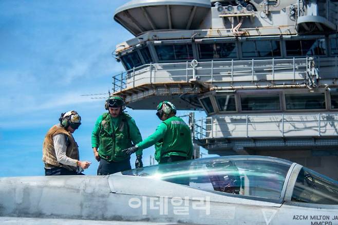 미 해군 핵항모 로널드 레이건함 승조원들이 비행갑판에서 이륙 대기중인 F/A-18E/F 전투기를 점검하고 있다. (사진=미 해군)