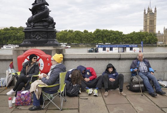 영국 시민들이 14일 여왕의 관 일반 공개를 기다리며 캠핑용 간이 의자 등을 펴놓고 대기하고 있다. AP=연합뉴스
