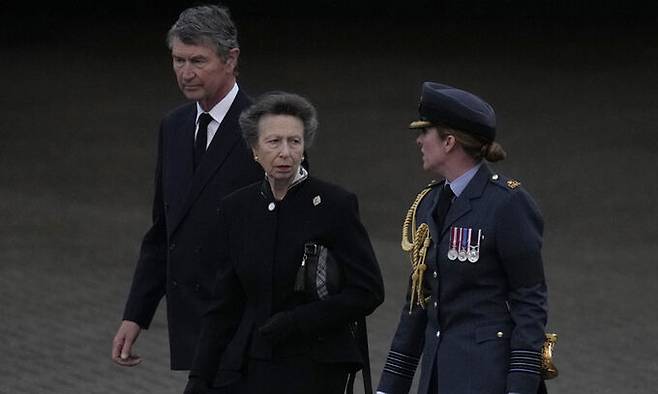 13일(현지시간) 영국 런던 서부 노솔트 공군기지에 막 착륙한 공군 수송기에서 내린 앤 공주(가운데)가 공군 관계자의 영접을 받으며 이동하고 있다. 공주 왼쪽은 남편인 티모시 로런스. 공주 부부는 이날 에든버러 공항에서 엘리자베스 2세 여왕의 관을 실은 군용기에 동승해 런던까지 비행했다. 런던=AP연합뉴스