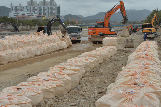 Officials from the Korean government, the Republic of Korea Navy and the Republic of Korea's Marine Corps work to repair a damaged riverside in Pohang, North Gyeongsang, after it took a serious hit due to Typhoon Hinnamnor on Sept. 6. Eight residents died due to the flood. [NEWS1]