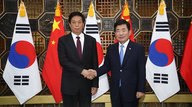 National Assembly Speaker Kim Jin-pyo (right) and Li Zhanshu, China's third-highest-ranking official and chief of the Standing Committee of the National People's Congress, shake hands ahead of their meeting at the National Assembly on Friday. (Yonhap)