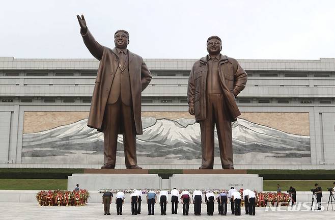 [평양=AP/뉴시스] 김정일 북한 전 국방위원장의 선군정치를 기념하는 '선군절' 62주년을 맞아 25일 평양 만수대언덕을 찾은 시민들이 김일성·김정일 동상에 참배하고 있다. 2022.08.25.