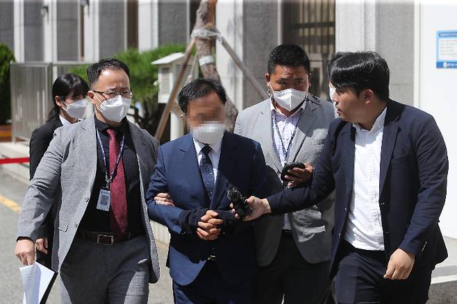 광주 학동4구역 재개발사업 조합장이 지난 15일 오전 광주지방법원에서 열린 구속 전 피의자 심문(영장실질심사)에 출석한 뒤 경찰 호송차로 이동하고 있다. 연합뉴스