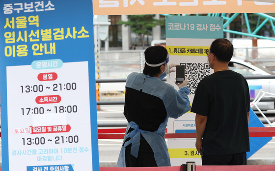 추석 연휴 기간에도 서울역 앞에서 운영된 코로나19 선별검사소에서 관계자가 시민을 안내하고 있다. 〈사진=연합뉴스〉