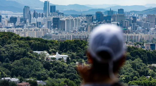 ▲24일 오전 서울 남산에서 바라본 서울 용산구 한남동 대통령 새 관저를 시민이 바라보고 있다. 윤석열 대통령 내외는 이달 말 즈음 관저의 리모델링이 완료되면 입주할 예정이다. ⓒ연합뉴스