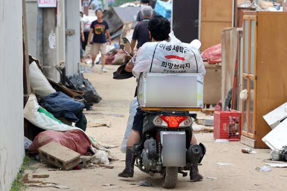 추석 당일인 지난 10일 경북 포항시 남구 대송면에서 한 이재민이 희망브리지가 세탁한 옷가지를 오토바이에 싣고 이동하고 있다. 희망브리지 제공