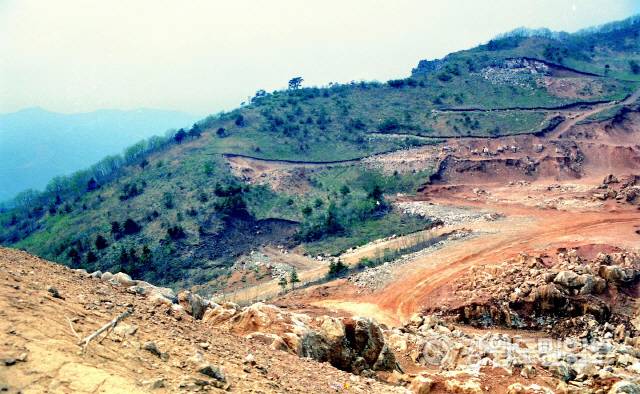 ▲ 백두대간 능선을 따라 굴곡지게 건설돼 험한 길의 대명사가 된 국도42호선 백봉령도로가 1117억원이 투입돼 오는 2025년 직선·터널화 돼 환동해권 물류와 관광에 새로운 수요 창출이 기대된다. 사진은 지난 2012년 백봉령의 주봉을 표식하는 의미가 있는 42번철탑이 있는 봉우리가 한라시멘트측의 무리한 석회석 채광으로 무너져 있는 모습.