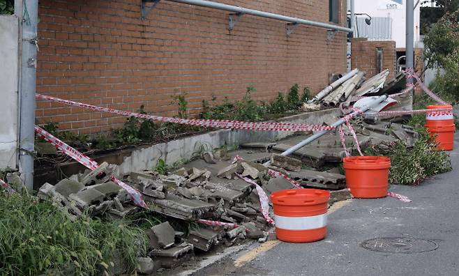 태풍경보가 발효 중인 19일 오전 부산 사하구의 한 건물 담장 10m 가량이 강풍에 쓰러져 있다. (사진=뉴시스)