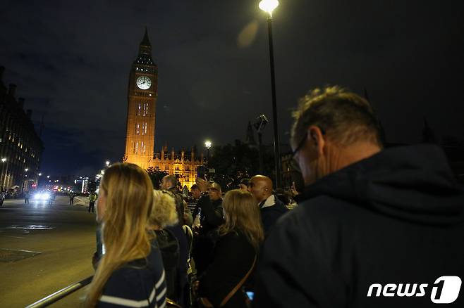 18일 오후(현지시간) 엘리자베스 2세 여왕의 관이 안치된 영국 런던 웨스트민스터 홀 인근에서 추모객들이 여왕을 위해 묵념하고 있다. 이날 오후 8시 영국 전역에서 여왕을 위한 1분간의 묵념이 이뤄졌다. 2022.9.19/뉴스1 ⓒ News1 안은나 기자