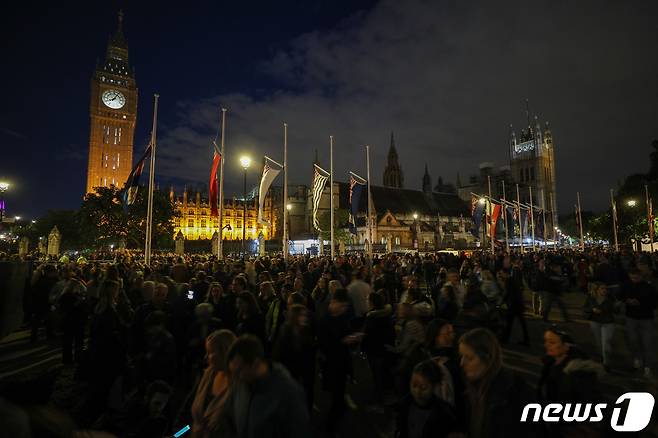 18일 오후(현지시간) 엘리자베스 2세 여왕의 관이 안치된 영국 런던 웨스트민스터 홀 인근에서 추모객들이 여왕을 위한 묵념이 끝나자 이동하고 있다. 이날 오후 8시 영국 전역에서 여왕을 위한 1분간의 묵념이 이뤄졌다. 2022.9.19/뉴스1 ⓒ News1 안은나 기자