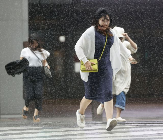 일본 규슈 서남부 가고시마 시민들이 지난 18일 제14호 태풍 ‘난마돌’에서 쏟아지는 강우를 우산 없이 뚫고 횡단보도를 건너고 있다. AP연합뉴스