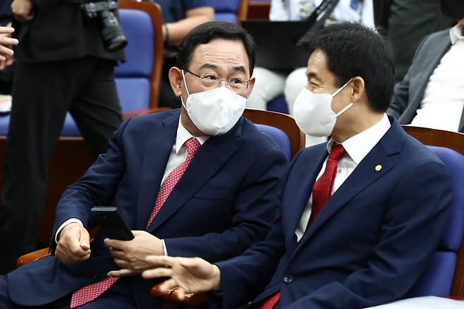 국민의힘 신임 원내대표 후보인 주호영(왼쪽), 이용호 후보가 19일 서울 여의도 국회에서 열린 의원총회에서 대화를 나누고 있다. /이덕훈 기자